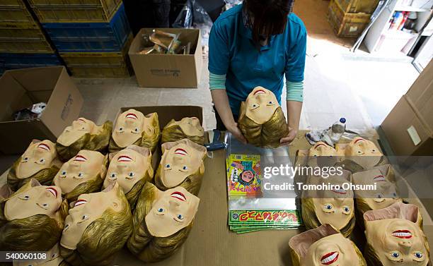 An employee packs a rubber mask in the likeness of Democratic presidential candidate Hillary Clinton at the Ozawa Studios Inc. Factory on June 14,...
