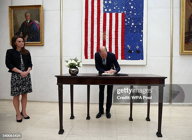 Prince WIlliam, The Duke of Cambridge signs a book of condolence for the Orlando mass shooting victims while Catherine, Duchess of Cambridge looks on...