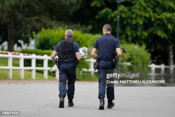 French policeman bring flowers on June 14, 2016 to the house in Magnanville where a man claiming allegiance to the Islamic State group killed a...