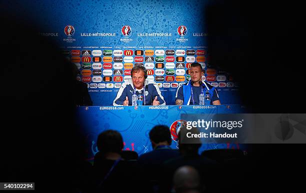 In this handout image provided by UEFA, Head Coach Jan Kozak of Slovakia talks to the media with Jan Durica during the Slovakia Press Conference at...