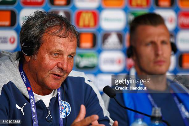 In this handout image provided by UEFA, Head Coach Jan Kozak of Slovakia talks to the media with Jan Durica during the Slovakia Press Conference at...