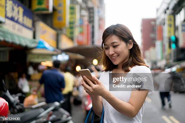 asian woman using her smart phone - east asia stock pictures, royalty-free photos & images