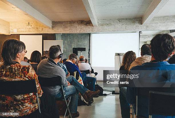 crowd audience looking at blank screen - auditorium presentation stock pictures, royalty-free photos & images