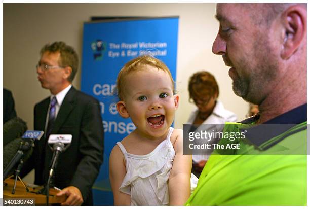 Hayley Walsh, 20 months, is all smiles in the arms of Dad, Trevor Walsh, after her Cochlear Implant. Hayley was born profoundly deaf and was...