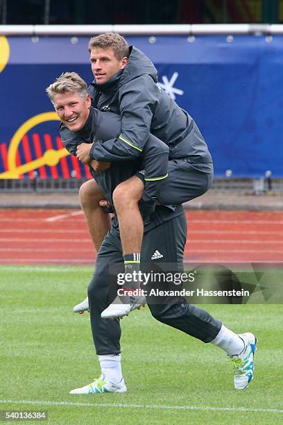 Bastian Schweinsteiger of Germayn jokes with his team mate Thomas Mueller during a Germany training session at Ermitage Evian on June 14, 2016 in...