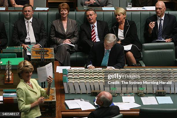 Federal Education Minister Julie Bishop reads from a book authored by Mark Latham called 'What Did You Learn Today' watched by Prime Minister John...