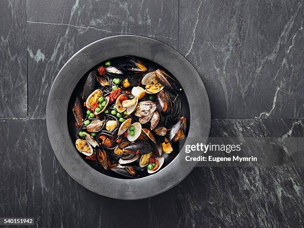 squid ink pasta with seafood and vegetables - seafood foto e immagini stock