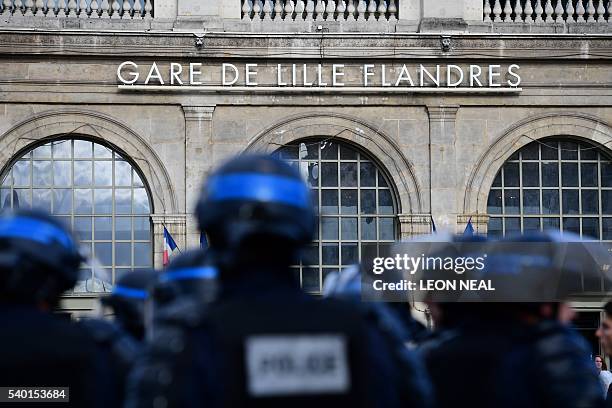 French police stand guard near the main train station as Russia football fans and England football fans gather in the city of Lille on June 14 three...