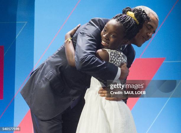 President Barack Obama embraces 11-year-old Mikaila Ulmer social entrepreneur of "Me and the Bees Lemonade" as he arrives to speak during the United...