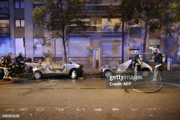 Firefighters intervene to extinguish the fire of two Autolibs in a street of Paris after been burnt by a group of hooded people.