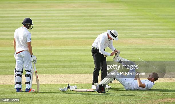 Umpire Rod Tucker helps Jonny Bairstow of England remove an obstacle from the sole of his shoe during day one of the 3rd Investec Test match between...