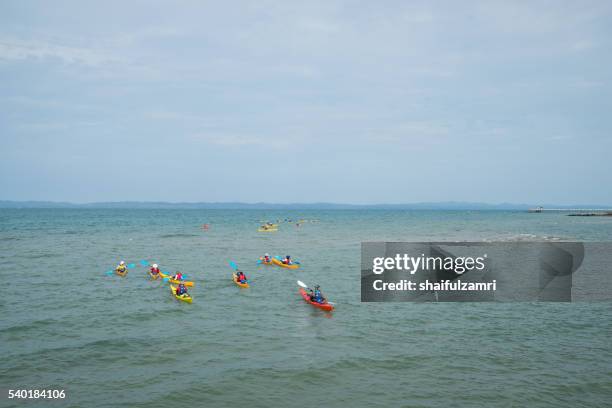 a group of students having fun in kayaks in sibu island of johor, malaysia. - sibu river stock pictures, royalty-free photos & images