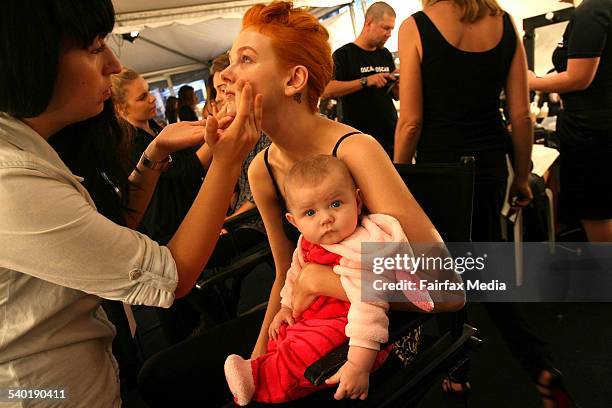 Model, Tiah Eckhardt, with her 6 month old daughter, Finley, has her make-up done before she goes on the catwalk for 2010 Australian Fashion Week.