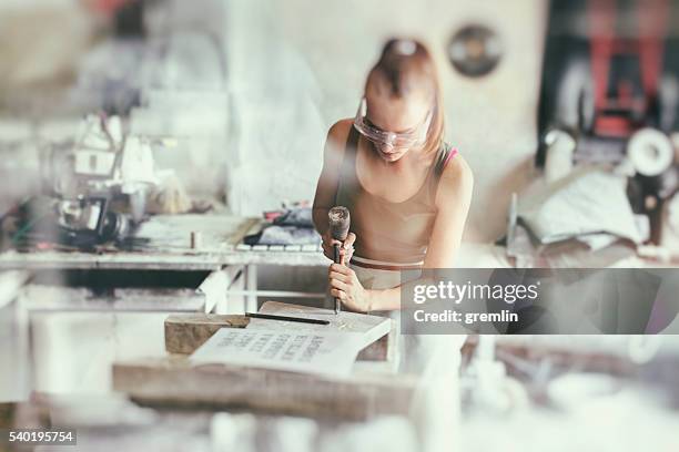 young woman stonemason in her workshop - chisel stock pictures, royalty-free photos & images