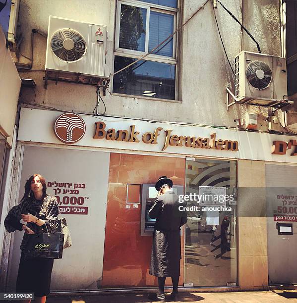 people getting cash from atm, bnei brak, israel - orthodox judaism stock pictures, royalty-free photos & images