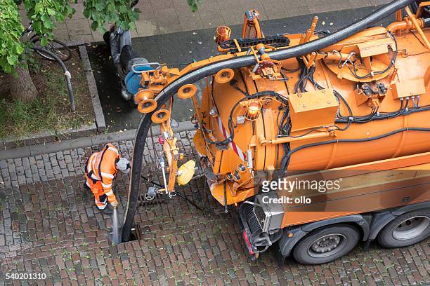 worker and sewage truck, high-angle view - sewage stockfoto's en -beelden