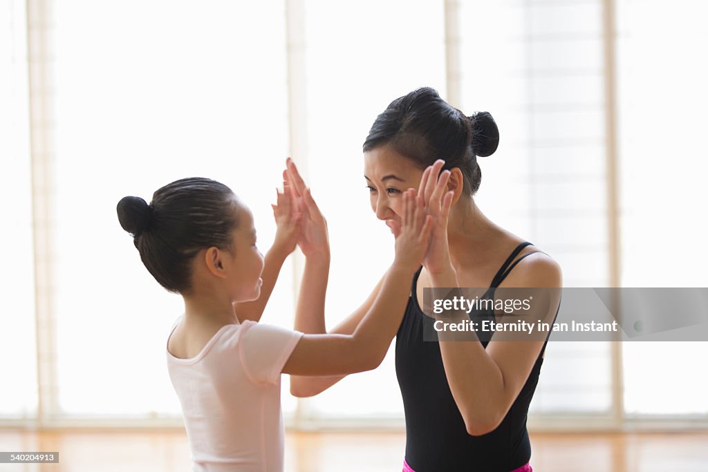 Ballet teacher congratulating young student.