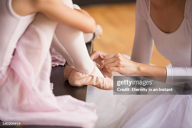 close up of ballet teacher helping her students - leotard and tights - fotografias e filmes do acervo