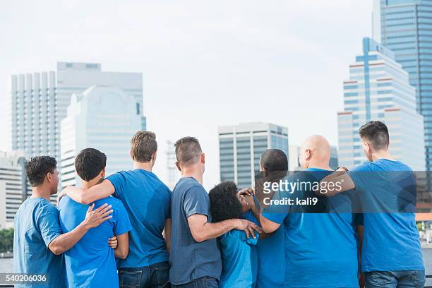 multi-ethnic fathers and sons standing together - blue tee stock pictures, royalty-free photos & images