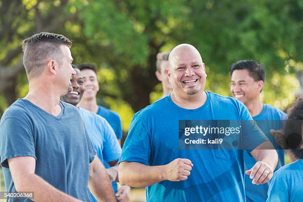 multi-racial group of men wearing blue shirts - cancer 2016 stock pictures, royalty-free photos & images