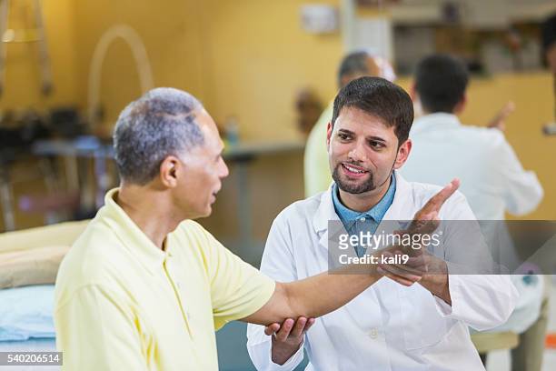 hispanic physical therapist, african american patient - orthopedic surgery stock pictures, royalty-free photos & images