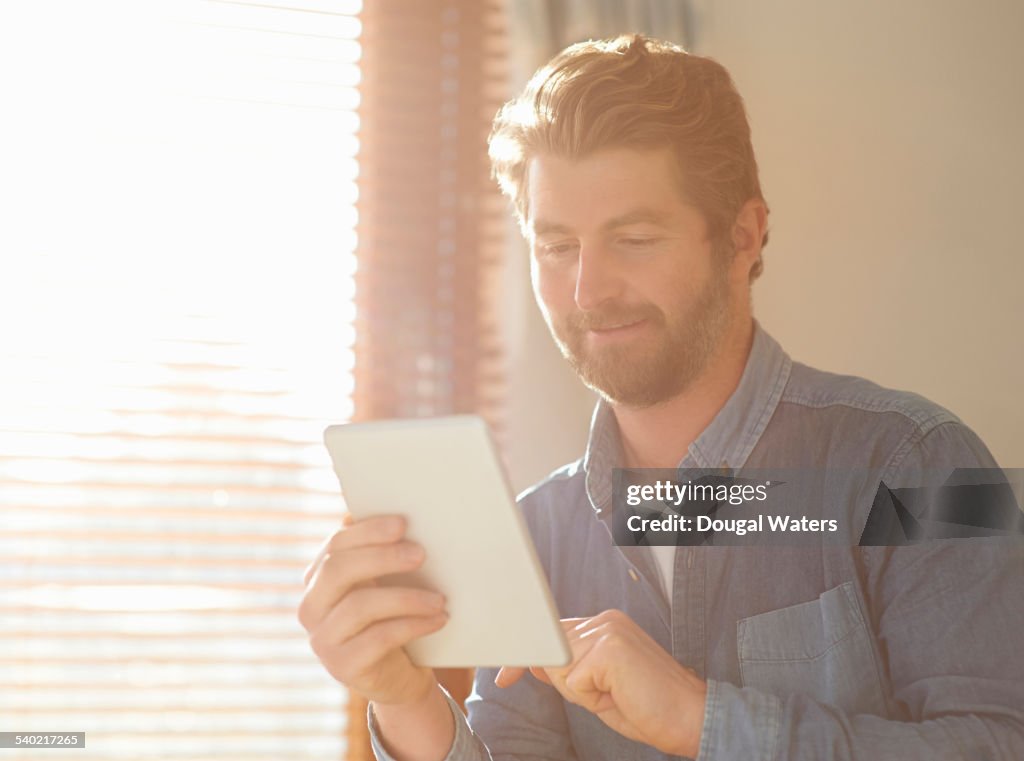 Man using digital tablet at home.