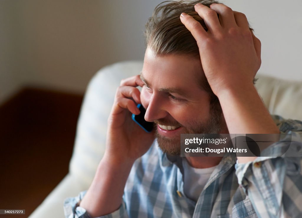 Man using mobile phone at home.