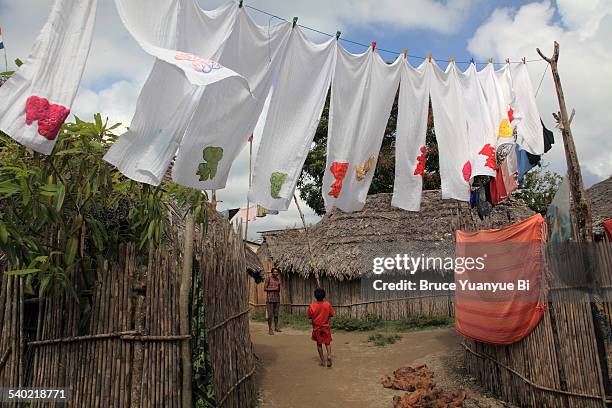 air drying cloth diapers hanging over village road - cloth nappy stock pictures, royalty-free photos & images