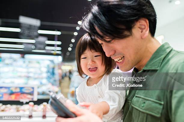vater mit seiner tochter-shopping - asian family shopping stock-fotos und bilder