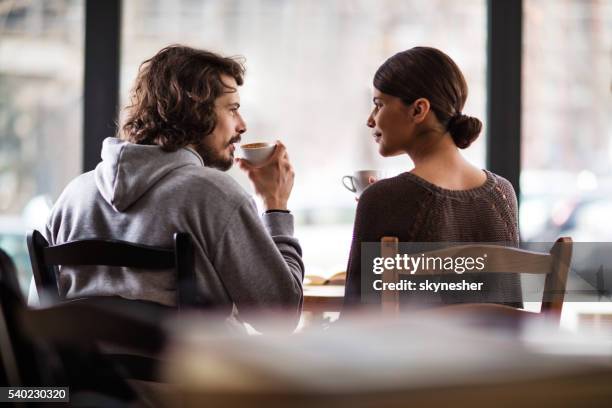 rear view of smiling couple in love enjoying in cafe. - couple in cafe coffee stock pictures, royalty-free photos & images