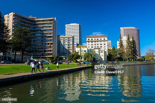 oakland downtown skyline and waterfront with people exercising - oakland california stock pictures, royalty-free photos & images