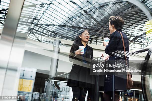 two businesswomen meeting at trainstation - gare ferroviaire photos et images de collection