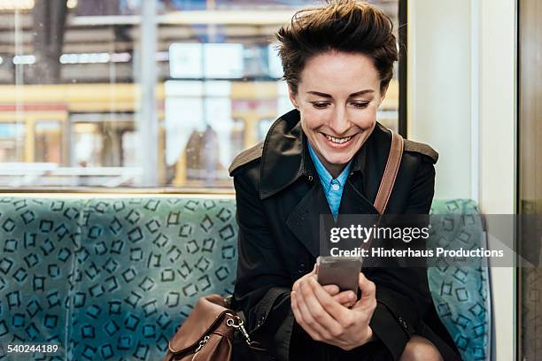 businesswoman with smart phone in commuter train - guardare verso il basso foto e immagini stock