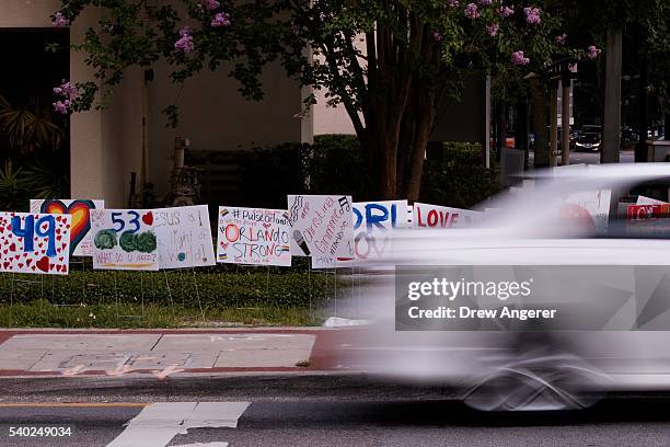 Car passes by signs of support for the victims of the Pulse Nightclub shooting, June 14, 2016 in Orlando, Florida. The shooting at Pulse Nightclub,...