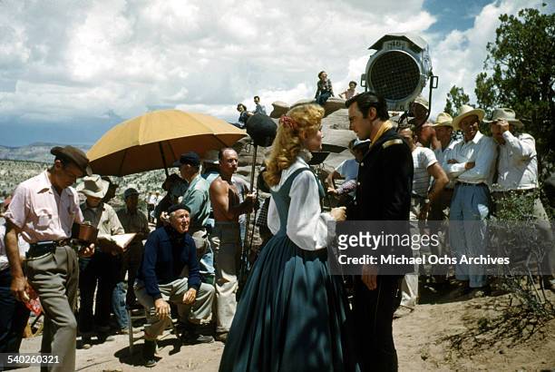 Actress Patrice Wymore on set while director William Keighley watches, as a film crew films the movie "Rocky Mountain" on location in Gallop, New...