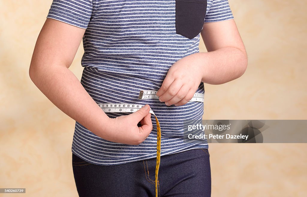 Obese child measuring herself