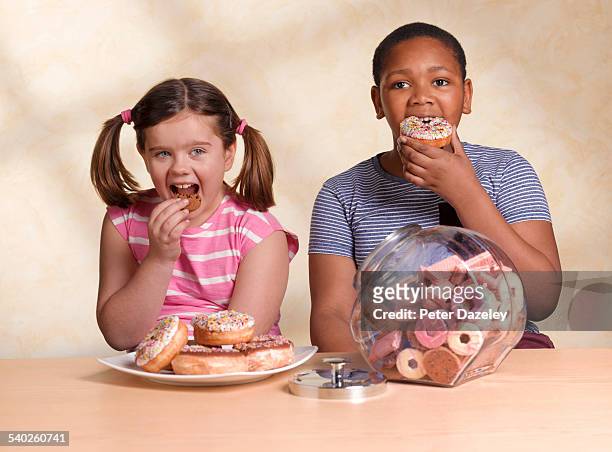 kids eating cookie and doughnut - child cookie jar stock-fotos und bilder