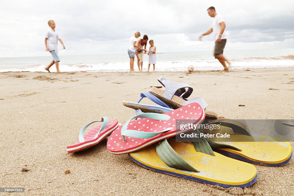 Family on beach, flip-flops in foreground