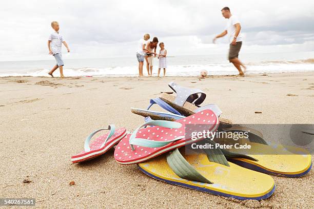 family on beach, flip-flops in foreground - chinelo sandália - fotografias e filmes do acervo