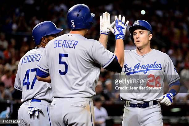 Chase Utley of the Los Angeles Dodgers is greeted at home by Howie Kendrick and Corey Seager after hitting two run home run in the seventh inning...