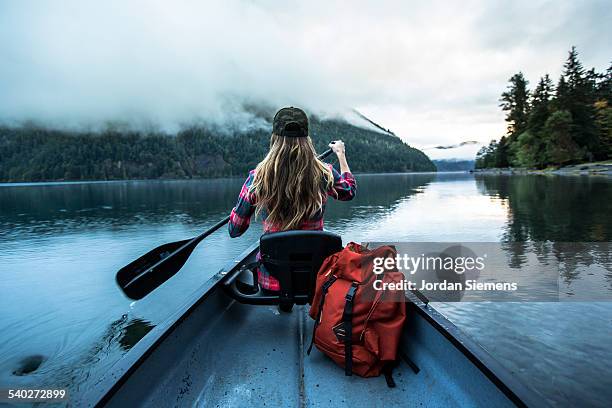 a woman in a canoe. - rowboat stock pictures, royalty-free photos & images