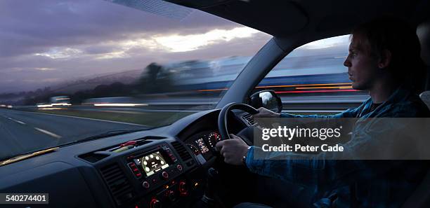 man driving a car/van on the motorway  at dusk - nutzfahrzeug stock-fotos und bilder