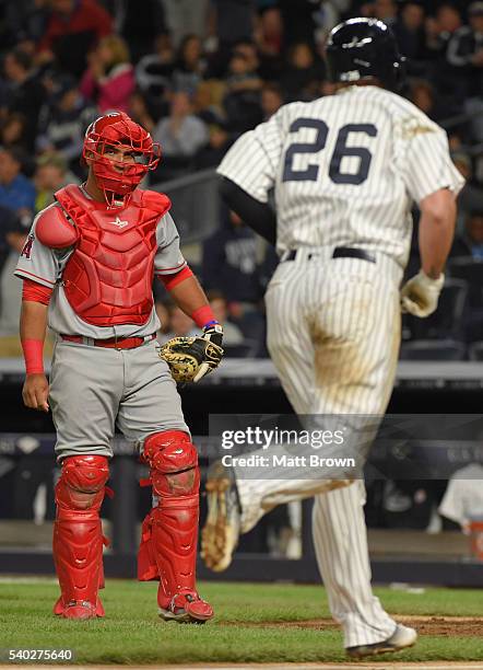 Cathcer Carlos Perez of the Los Angeles Angels of Anaheim watches as Chris Parmelee of the New York Yankees runs the bases after hitting a solo home...