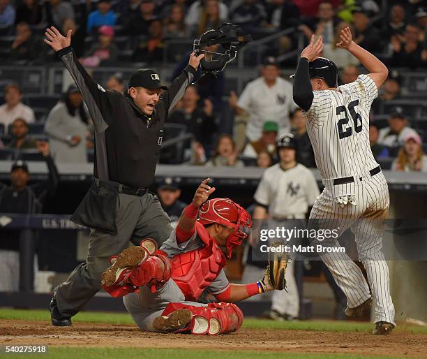 Umpire Clint Fagan signals safe as Chris Parmelee of the New York Yankees scores past the tag of Carlos Perez of the Los Angeles Angels of Anaheim...