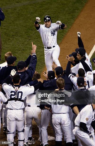 Derek Jeter of the New York Yankees celebrates his game winning home run in the 10th inning against the Arizona Diamondbacks during game four of the...