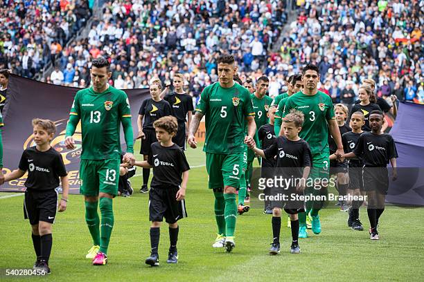 Alejandro Melean, Nelson Cabrera and Luis Gutierrez of Bolivia walk on to the field with player escorts before a group D match between Argentina and...