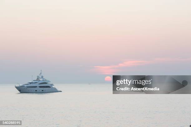 distant view of private yacht and sunrise - luxury yacht stock pictures, royalty-free photos & images