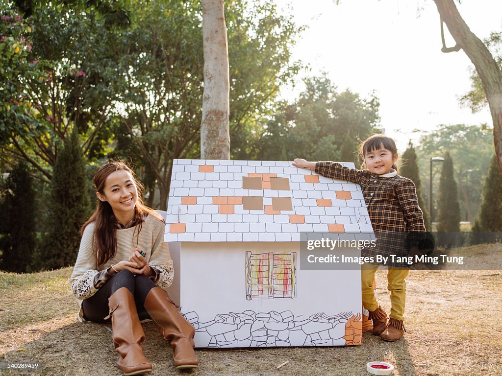 Mom & daughter taking pictures with a playhouse