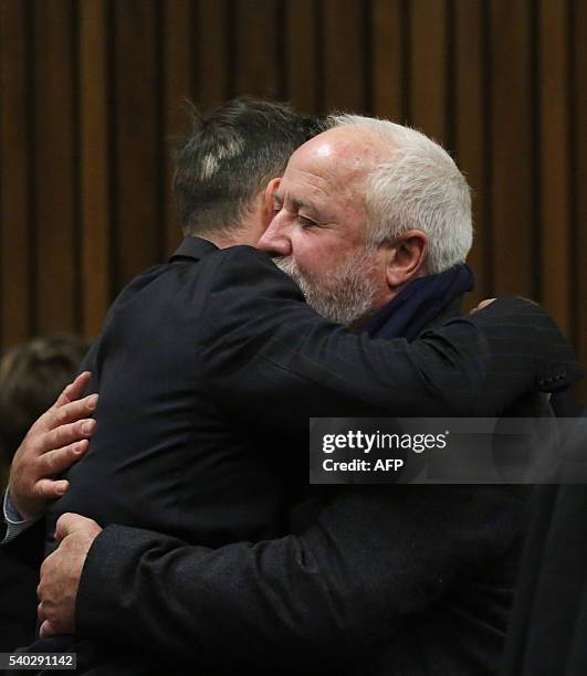 South African Paralympian Oscar Pistorius hugs his father Henke Pistorius on the third day of his hearing at the Pretoria High Court for sentencing...