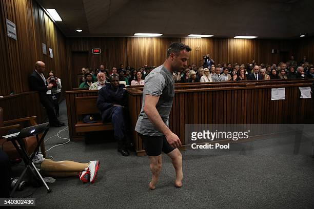 Oscar Pistorius walks across the courtroom without his prosthetic legs during the third day of Oscar's hearing for a resentence at Pretoria High...